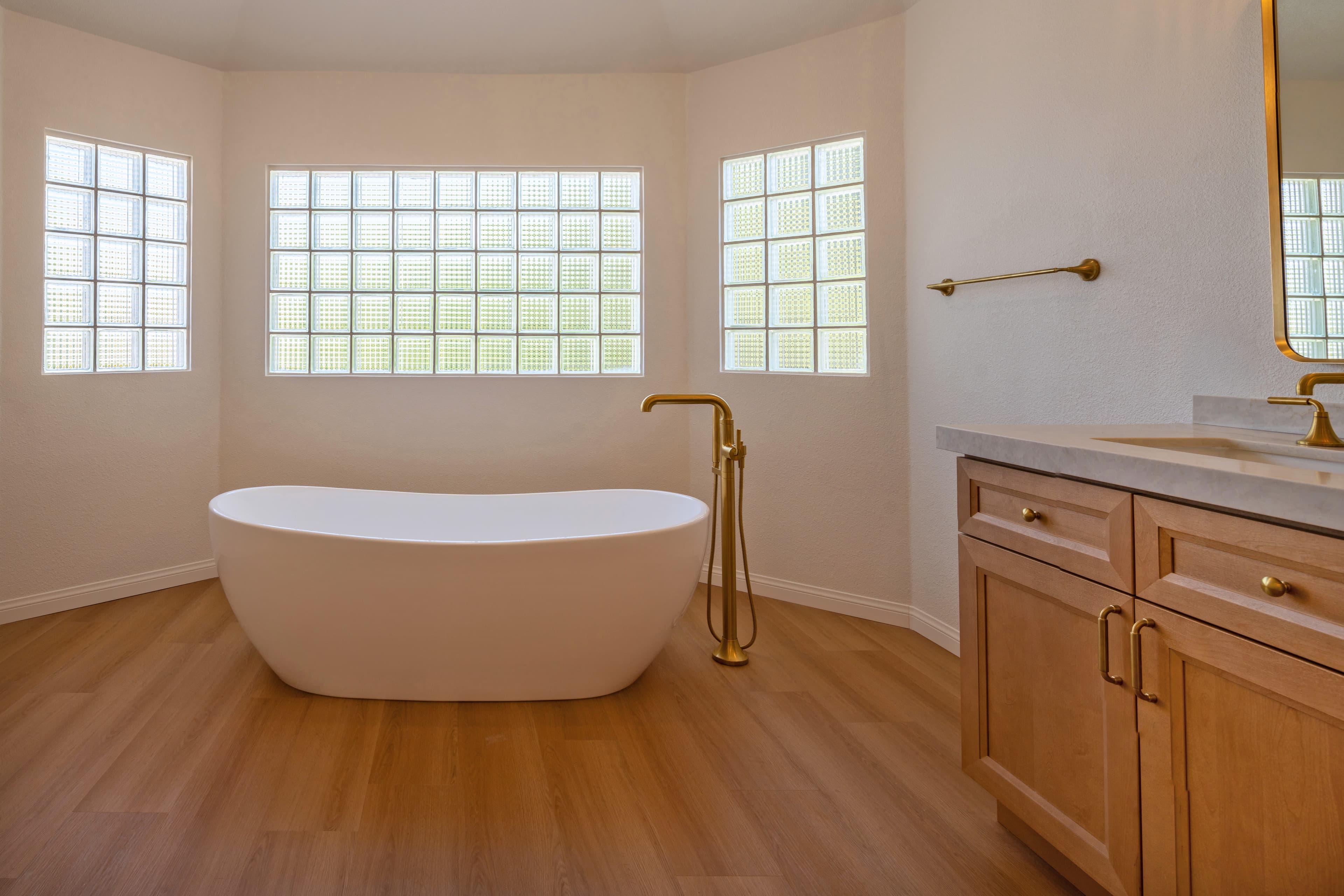 Finished master bathroom — freestanding tub, gold fixtures